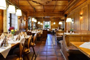 A restaurant with wooden interiors, tables set with white tablecloths, and hanging lamps. - Landgasthof zum Erdinger Weissbrau (Rosenheim)