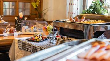 A buffet setup with various food items and a chef's hat decoration.