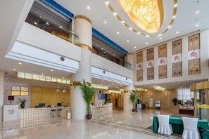 A spacious lobby with a reception desk, seating area, and decorative elements. - Jinzun International Hotel (ZAOZHUANG)