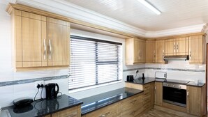 Una cocina moderna con armarios de madera, encimera negra y horno empotrado.