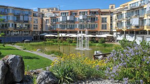 A hotel with multiple balconies, outdoor dining areas, and a central water feature. - Dorint Parkhotel Bad Zurzach (Bad Zurzach)