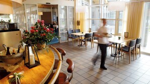 A modern hotel lobby with a bar area, a dining space, and large windows offering views. - Dorint Parkhotel Bad Zurzach (Bad Zurzach)