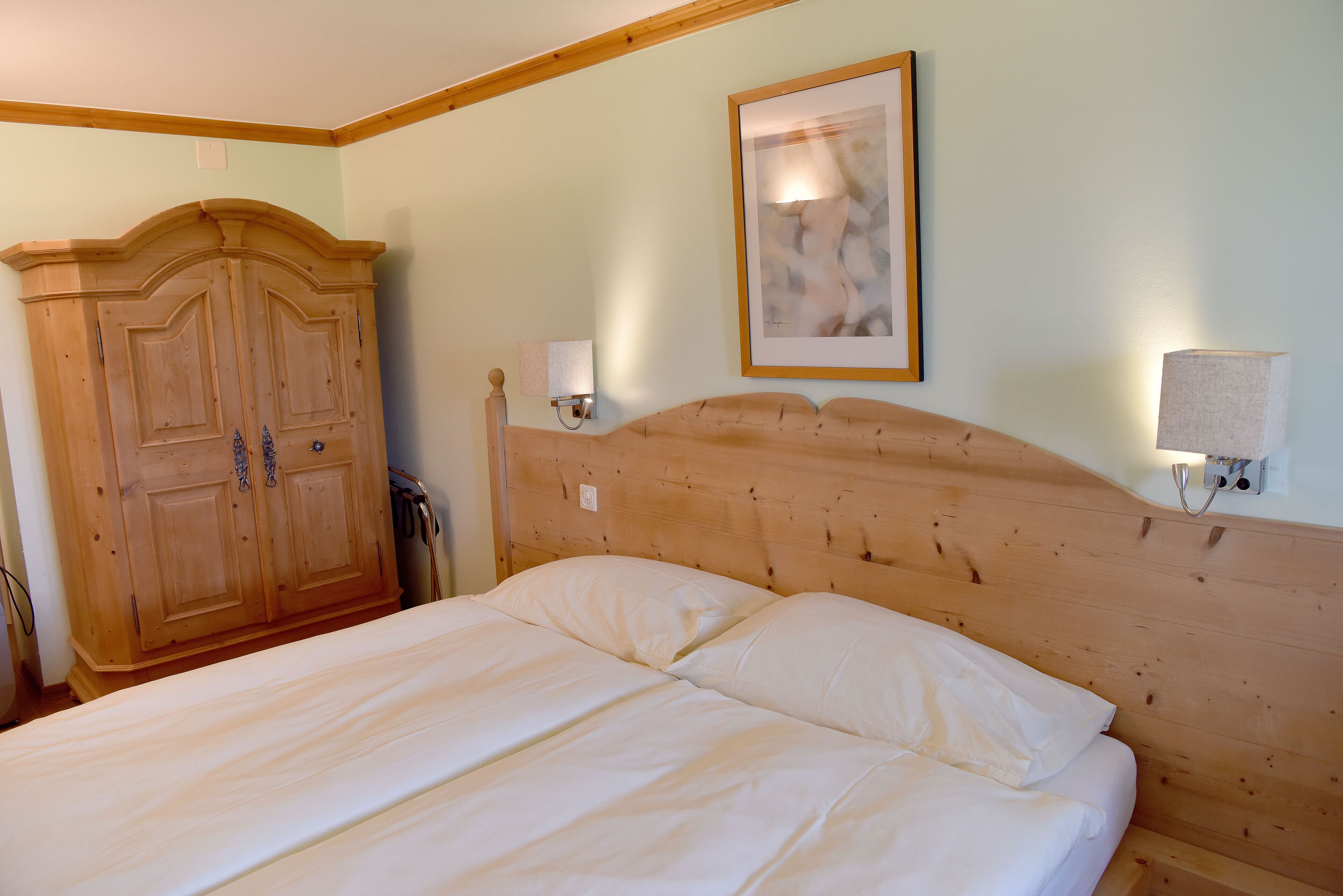 Un dormitorio con cabecera de madera, un armario grande y un cuadro en la pared.