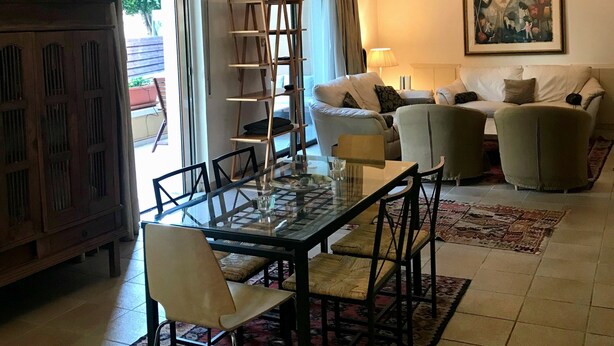 A living room with a glass-top dining table, chairs, a sofa, a ladder, and a chandelier. - Stone-house in the heart of Nicosia (Nicosia)