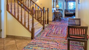 Una escalera con balaustres de madera que conduce a un rellano alfombrado.