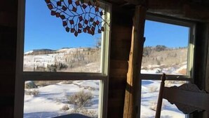 Una habitación con un ventanal grande que da a un paisaje nevado.