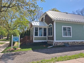 A small, single-story house with a porch, a covered entryway, and a sign indicating it's a cottage.