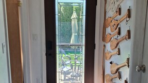 Una habitación con puerta de madera, un banco, un tapete y una pared con palas de madera.
