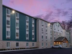 A multi-story hotel with a stone facade, multiple windows, and a parking lot.