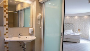 A modern bathroom with a sink, mirror, and hairdryer. - Bastya Wellness Hotel (Miskolc)