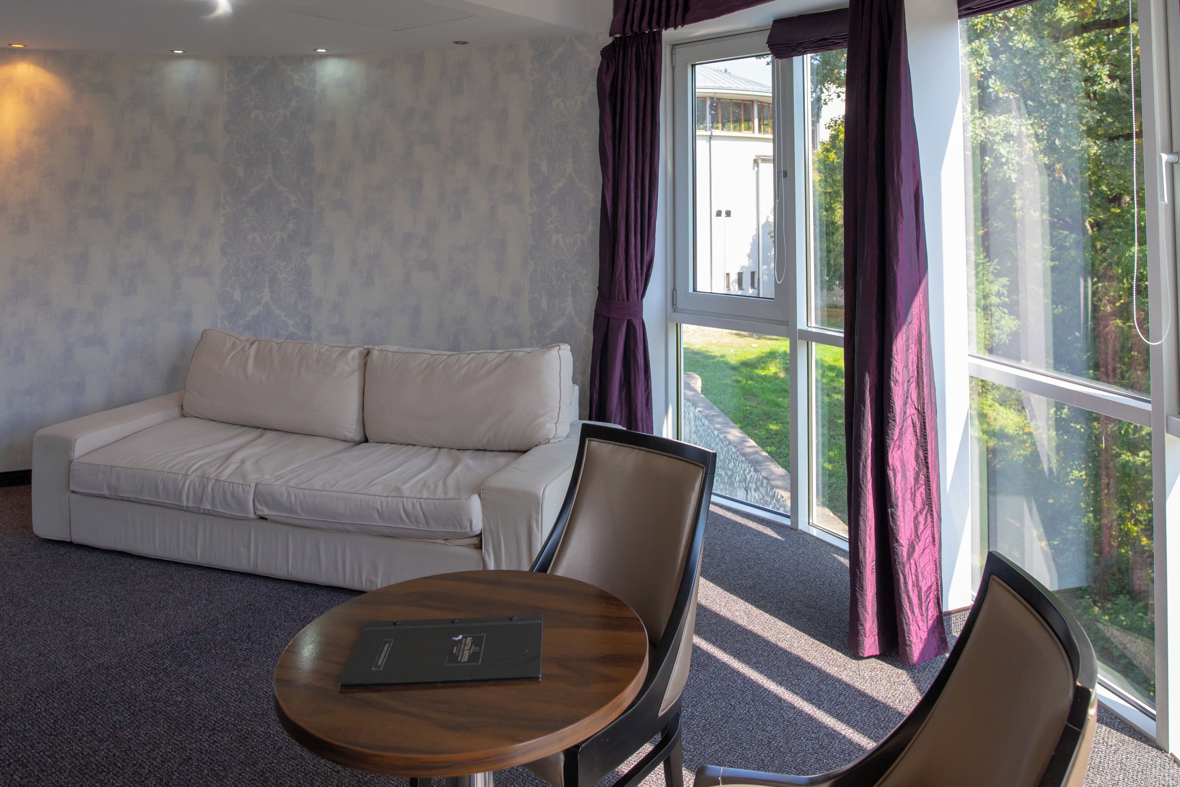 A modern room with a sofa, a round table, and a chair.