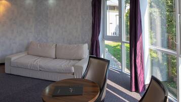 A modern room with a sofa, a round table, and a chair.