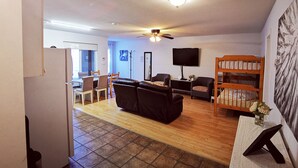 A living room with a sofa, chairs, a TV, a ceiling fan, and a bookshelf. - Bear Creek Suite (Surrey)