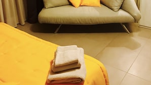 Una habitación con cama, sofá y una lámpara.