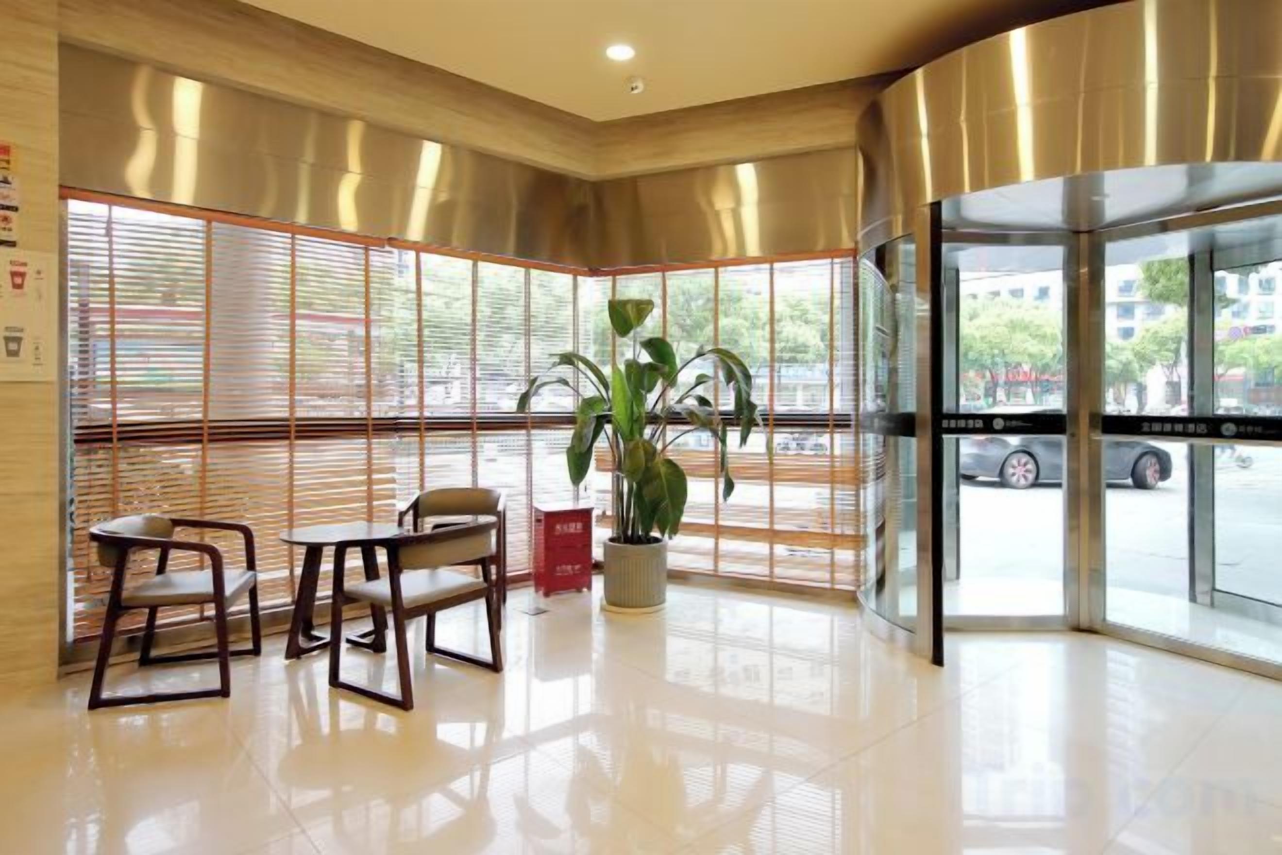 Un vestíbulo de hotel con techo curvo, ventanas amplias y una planta en maceta.