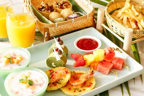 Diversos alimentos, como brochetas de fruta, camarones y un plato con una bebida y postre.