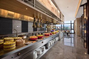 Une cuisine moderne dotée d’appareils électroménagers en acier inoxydable, de plans de service en bois et offrant une vue sur la ville.
