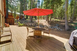 Enjoy al fresco dining on this serene deck surrounded by a lush forest.