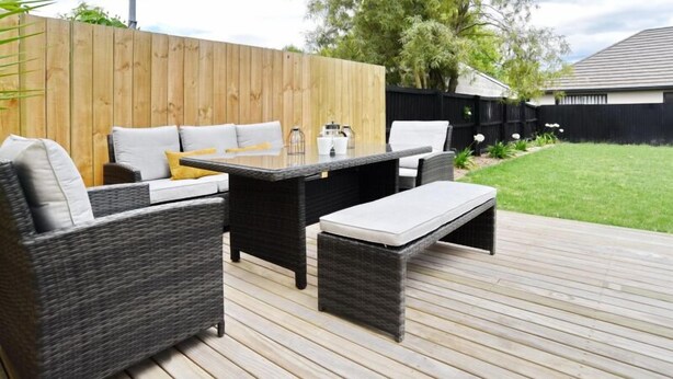 An outdoor patio with wicker furniture, a table, and a bench. - Room to spread out · fenced lawn, pets welcome - Weston Villa (St Albans)