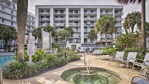 A hotel pool area with lounge chairs, a hot tub, and a sign indicating no class on the pool. - Gulf Shores Getaway w/ Pool, Spa & Beach Access! (Gulf Shores)