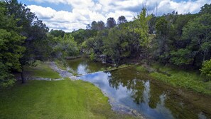 Un paysage naturel comprenant une rivière, des zones herbeuses et des arbres denses.