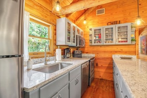 Una cocina con encimeras de granito, electrodomésticos de acero inoxidable y armarios de madera.