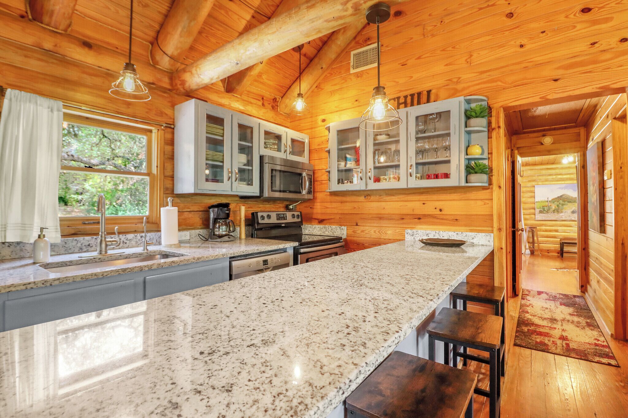 A kitchen with granite countertops, stainless steel appliances, and wooden cabinetry.