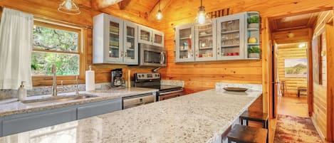 Una cocina con encimeras de granito, electrodomésticos de acero inoxidable y armarios de madera.