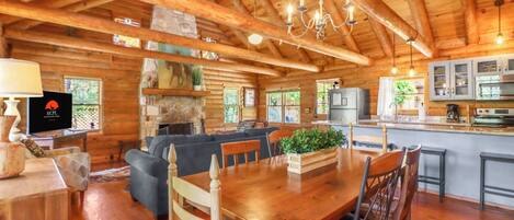 A spacious lodge interior with a dining area, kitchen, and living room.