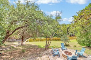 A patio area with outdoor seating and a fire pit. - Hill Country Log Cabin Near Wimberley | Hot Tub, Fire Pit & Scenic Views (Wimberley)