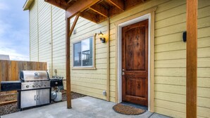 A residential exterior with a wooden door, a garage door, and a barbecue grill. - Secluded Nampa Idaho Home, Near Shopping (Nampa)