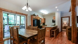 A spacious kitchen with wooden cabinets, a large dining table, and a built-in island. - Indoor Pool - Sleeps 22 - 8 King Beds - Right by SDC - Vanessa's Vacation Homes (Branson)