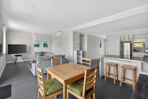 A modern apartment with a dining area, kitchen, and living room.