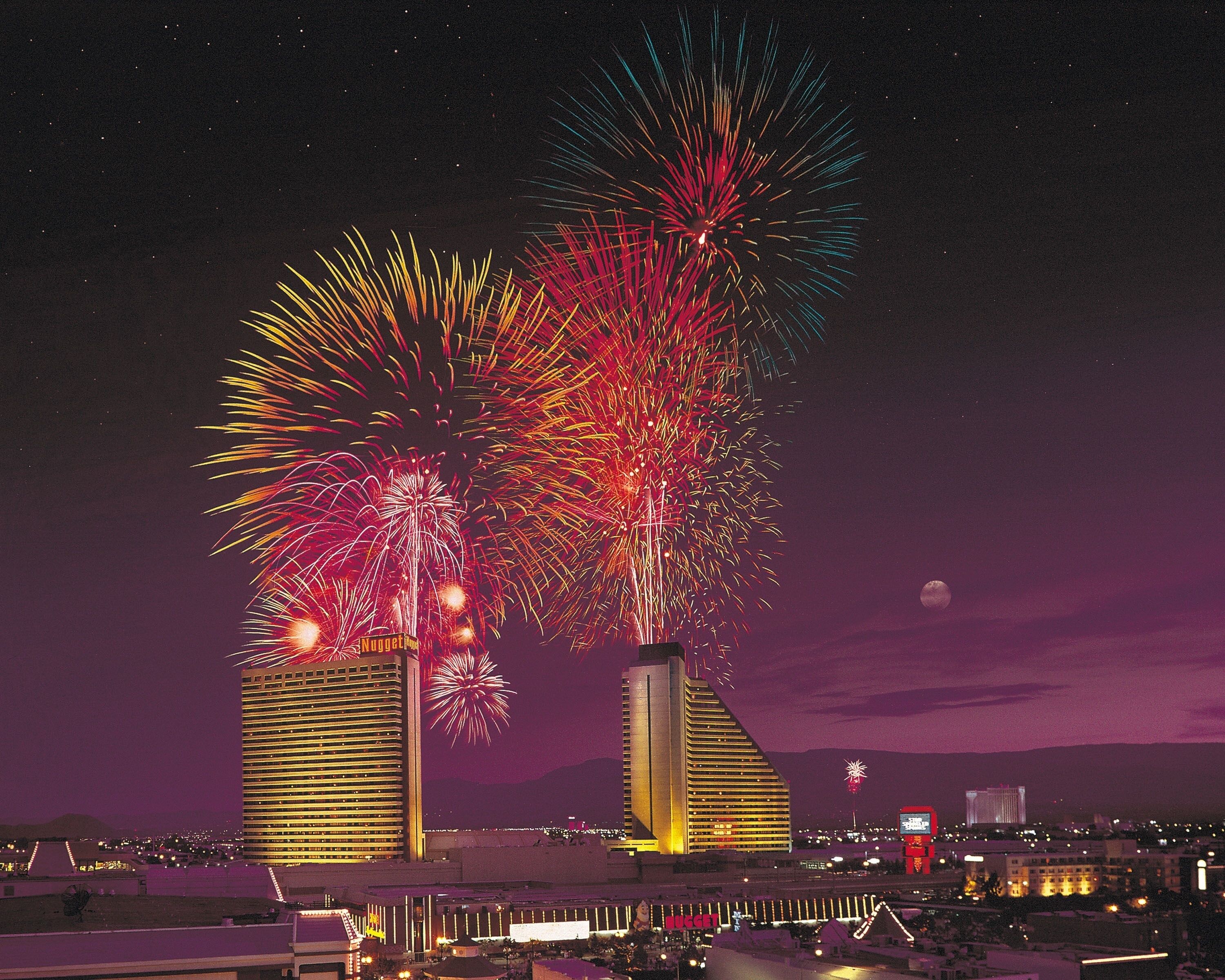 A nighttime view of a cityscape with a prominent building featuring a unique architectural design.