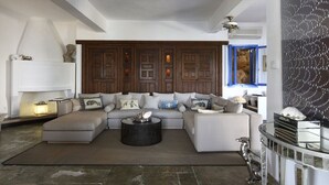 A modern living room with a sectional sofa, a round coffee table, and a decorative wall panel. - Beach Front, Romantic Escape, Breathtaking Views, 'Pieds dans L'eau', & More (Magnesia)