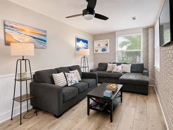 A modern living room with two grey sofas, a coffee table, and a floor lamp.