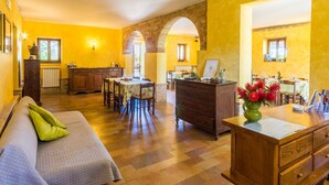 Une pièce chaleureuse avec un canapé, une commode en bois et une table à manger avec des chaises.