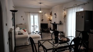 Un salon moderne comprenant un canapé, un téléviseur, une cheminée, une table à manger et des chaises.