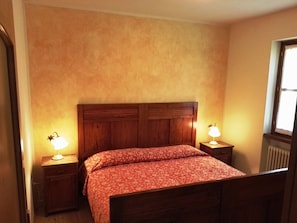 Cozy retreat with a floral-patterned bedspread, bedside tables, and a window for natural light.