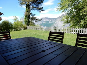 Situated in a serene natural setting, this outdoor seating area offers a peaceful retreat with a table and two chairs.