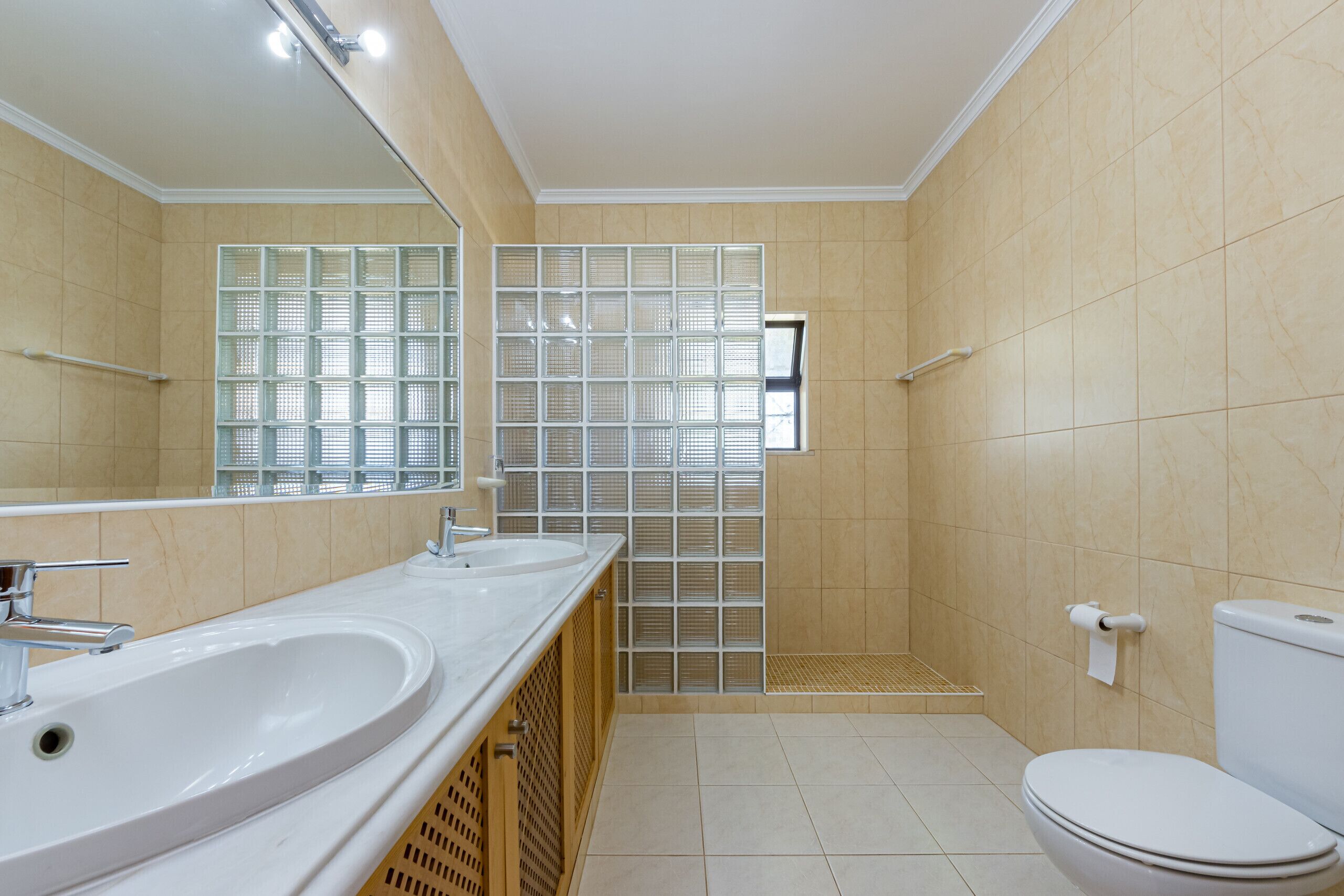 Ein Badezimmer mit Waschbecken, Spiegel, Toilette und Duschbereich.