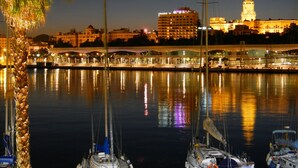 A marina at night with boats docked, a bridge, and illuminated buildings in the background. - Morlaco apartment (Málaga)