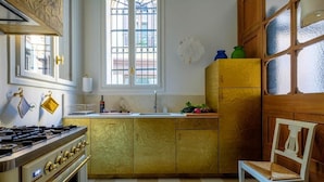 A kitchen with a stove, oven, and a window with a view of the outside.