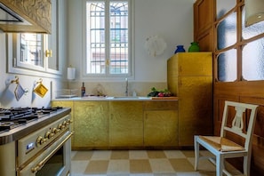 A kitchen with a stove, oven, and a window with a view of the outside. - Ca' del Ramo D'oro (Venice)