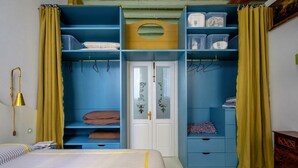 A bedroom with a bed, a wardrobe, and a nightstand.