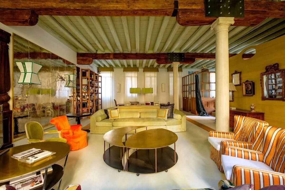 Un vaste espace de vie comprenant un grand canapé, une table basse et une bibliothèque.