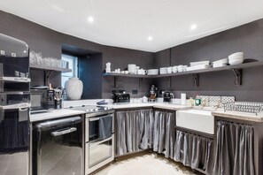 Een moderne keuken met een inbouwoven, magnetron en koffiezetapparaat.