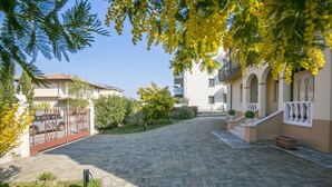 A paved courtyard with a stone pathway, surrounded by buildings with balconies and windows. - Villa Mimosa Near Desenzano Old Town Apt 2 Parking, A/C, WiFi, Desenzano Del Garda, Italy (Desenzano Del Garda)