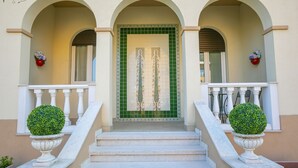 A building entrance with a green tiled door, white balustrades, and two potted plants on either side of the steps. - Villa Mimosa Near Desenzano Old Town Apt 2 Parking, A/C, WiFi, Desenzano Del Garda, Italy (Desenzano Del Garda)