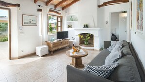 A living room with a sofa, a coffee table, a fireplace, and a television. - VILLA  MARGARITA - 15 MIN WALK TO THE BEACH (Puerto Pollensa)